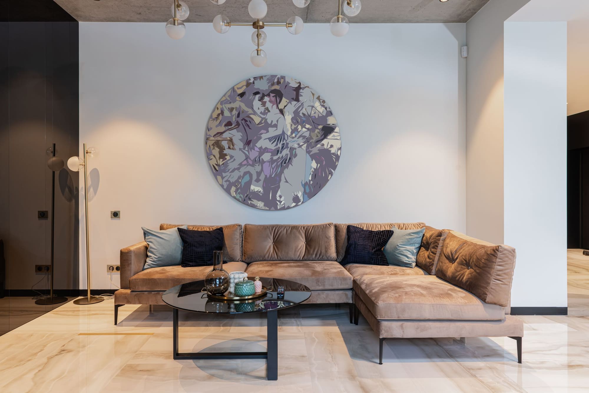 Modern living room with tan sectional sofa, round abstract wall art, and black coffee table
