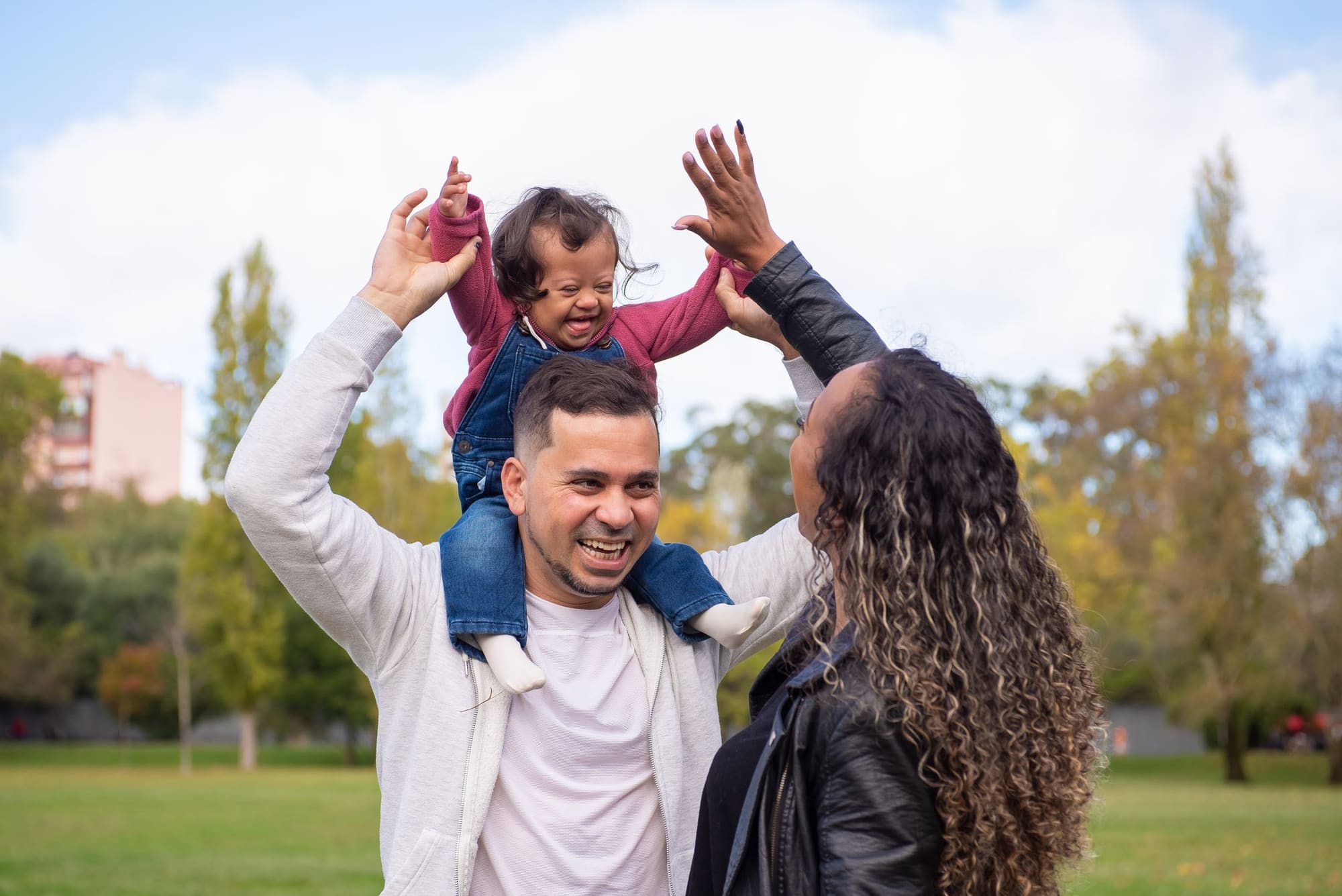 Happy family playing together in a park on a sunny day