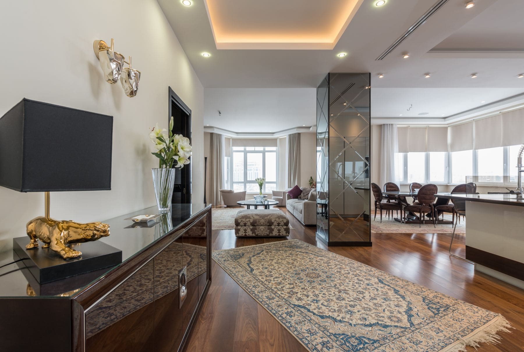 Luxury penthouse living room with floor-to-ceiling windows, modern furnishings, and gold accents